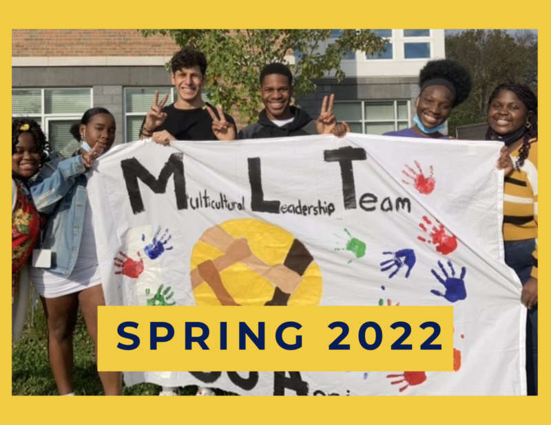 students holding an MLT banner, in the foreground, text that reads SPRING 2022