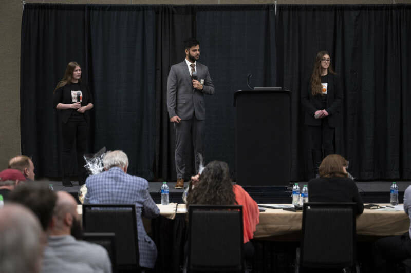 Photo of all three team members giving presentation at West Virginia Business Plan Competition.