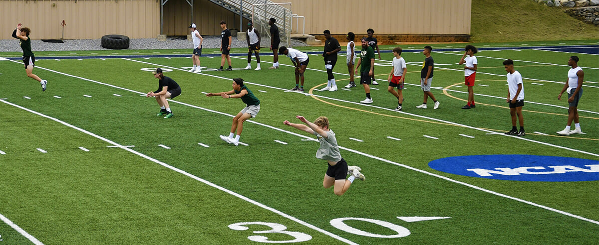 High school football players working out in Ram Stadium.