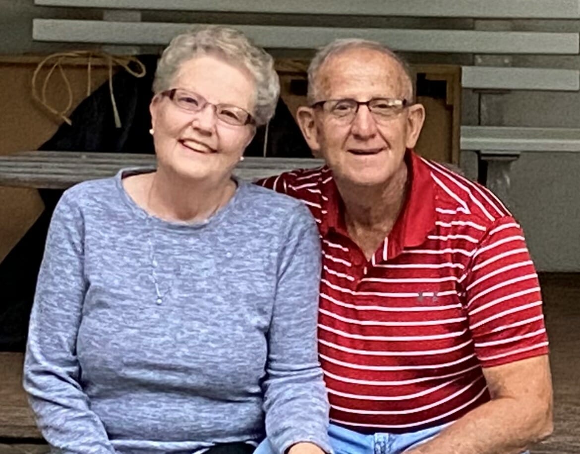 Photo of Dianne and Michael Alvarez sitting next to each other smiling, looking at the camera.
