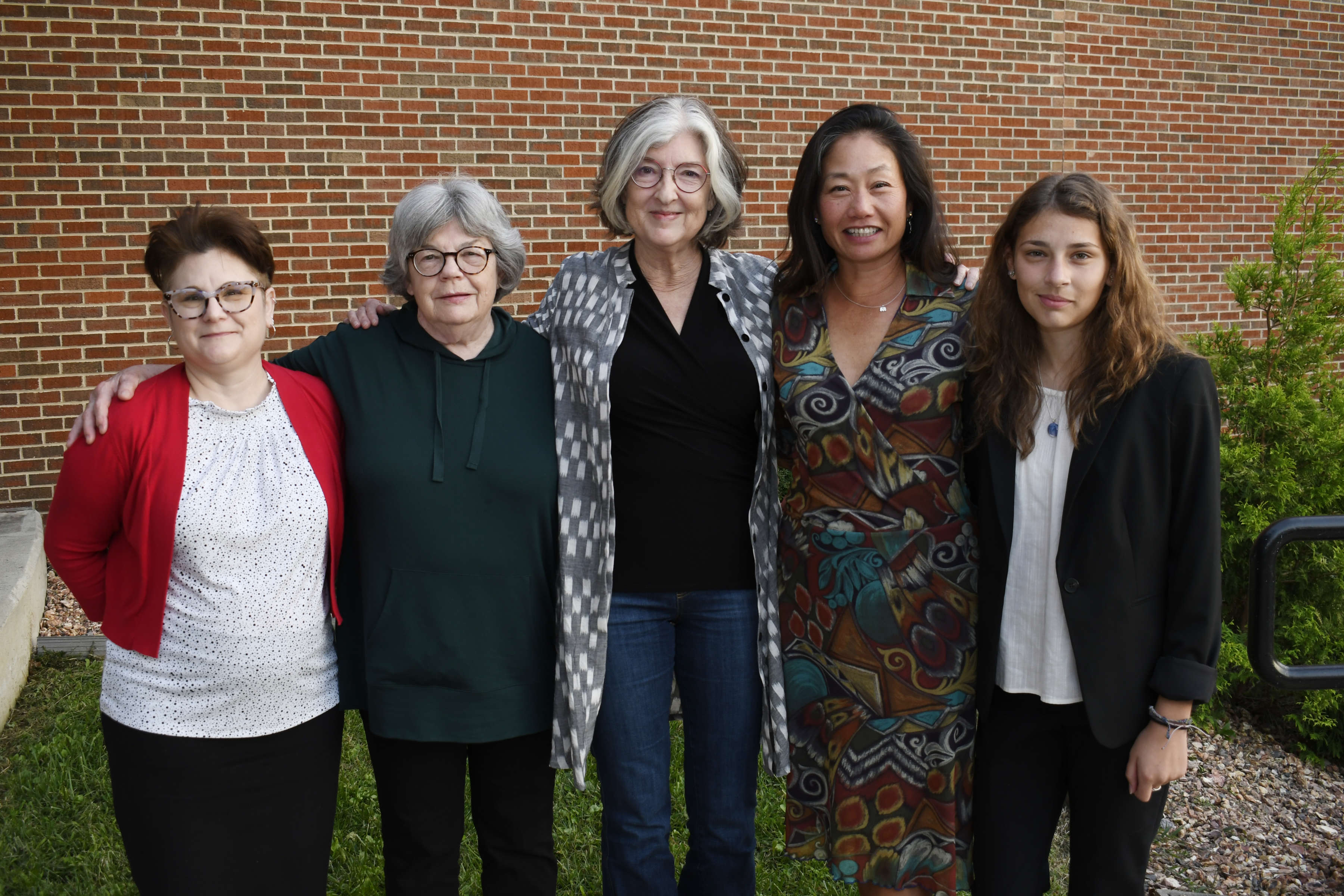 Photo of writer Barbara Kingsolver with winners of fiction competition standing in front of a brick wall.