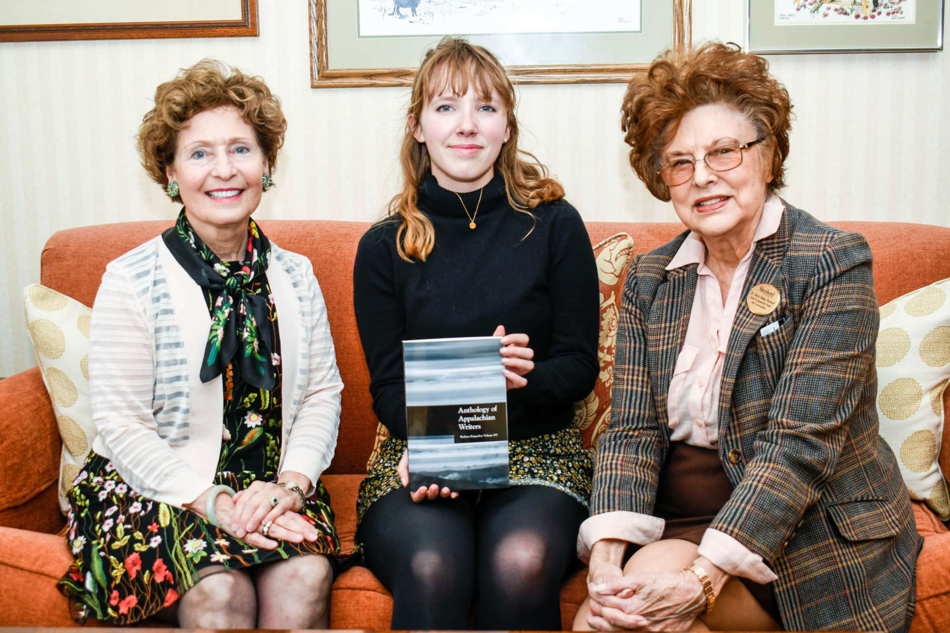 Photo of Dr. Mary J.C. Hendrix, Noche Gauthier, and Dr. Sylvia Bailey Shurbutt sitting on couch in president's office, Noche holding Anthology book.