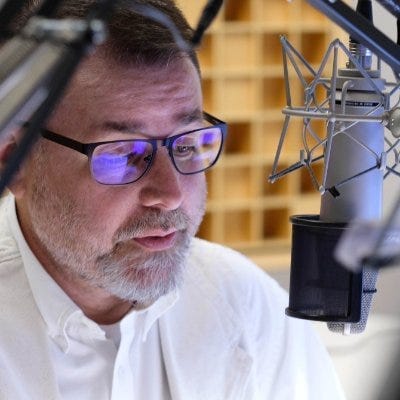 Photo of Giles Snyder at the microphone at NPR.