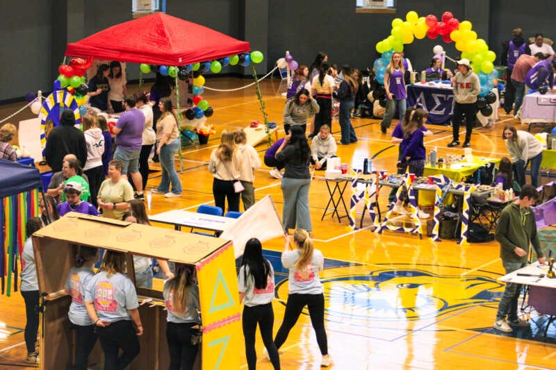 Community event with students holding fundraising activites on basketball courts